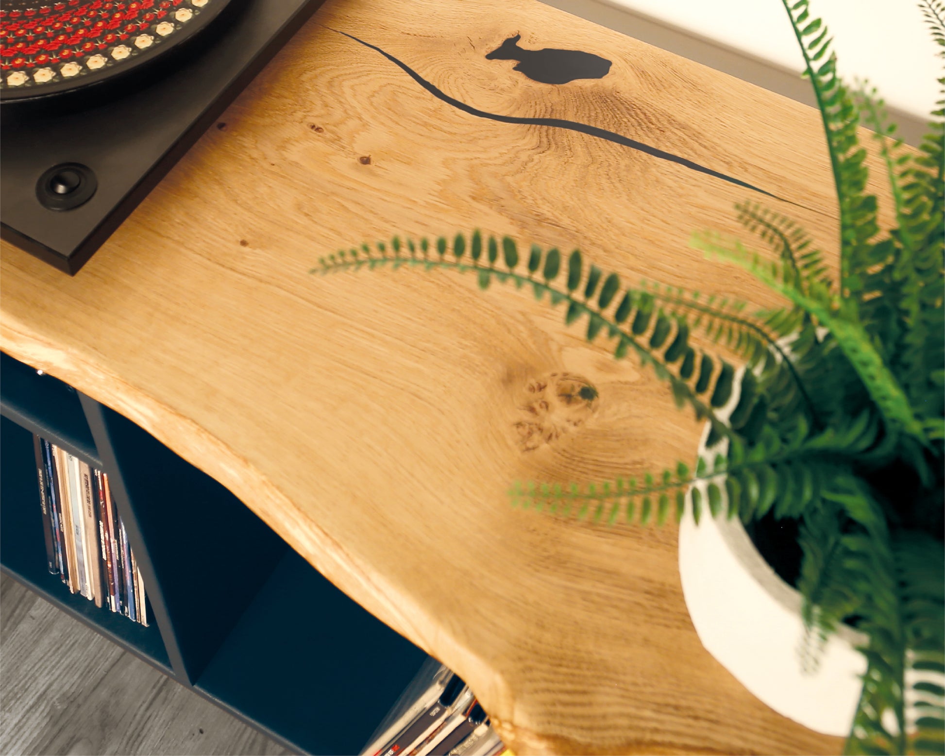 Close-up view of the solid oak top, highlighting the anthracite black resin filler that fills natural cracks, transforming imperfections into a striking design feature.