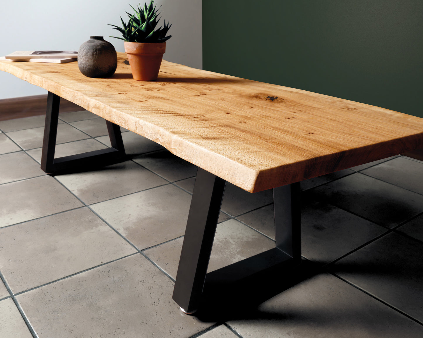 Stylish live edge coffee table featuring natural waney edges, black resin filler, and sleek black trapezoid legs. A unique stand-out piece.