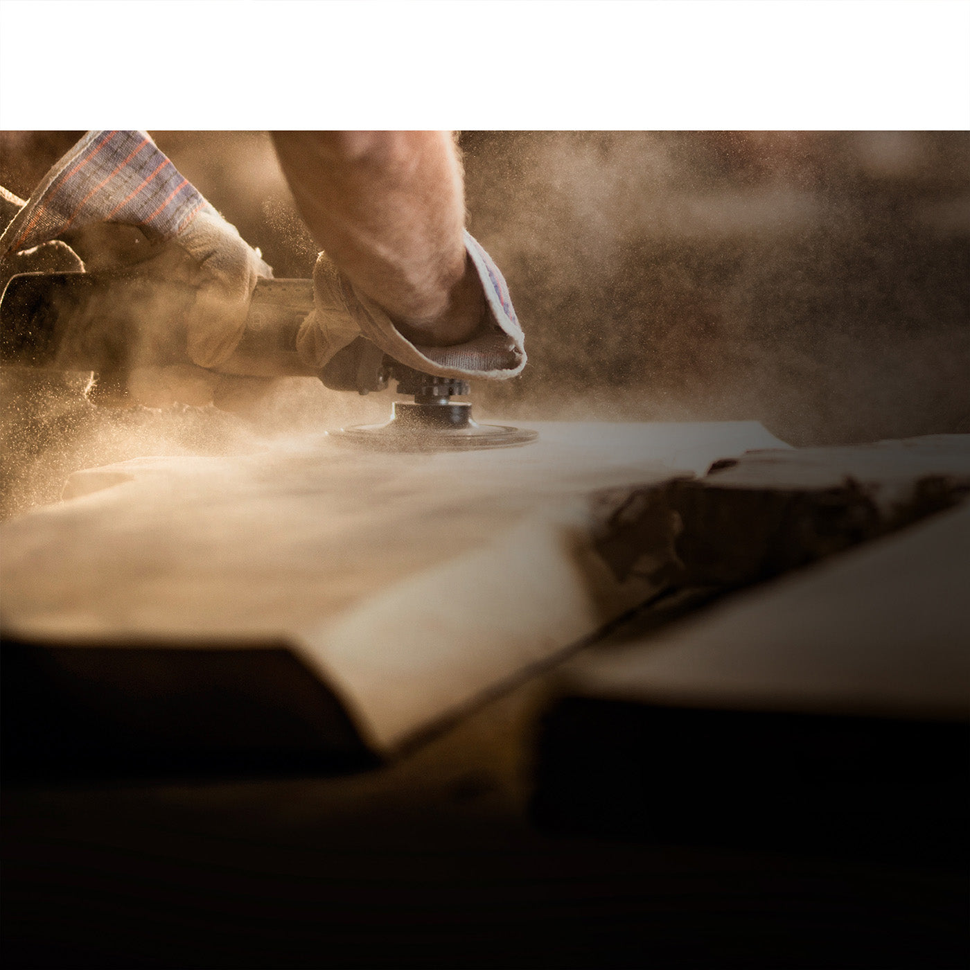 close up of a live edge oak board being sanded showing the process and craftsmanship in the Kontur studios workshop