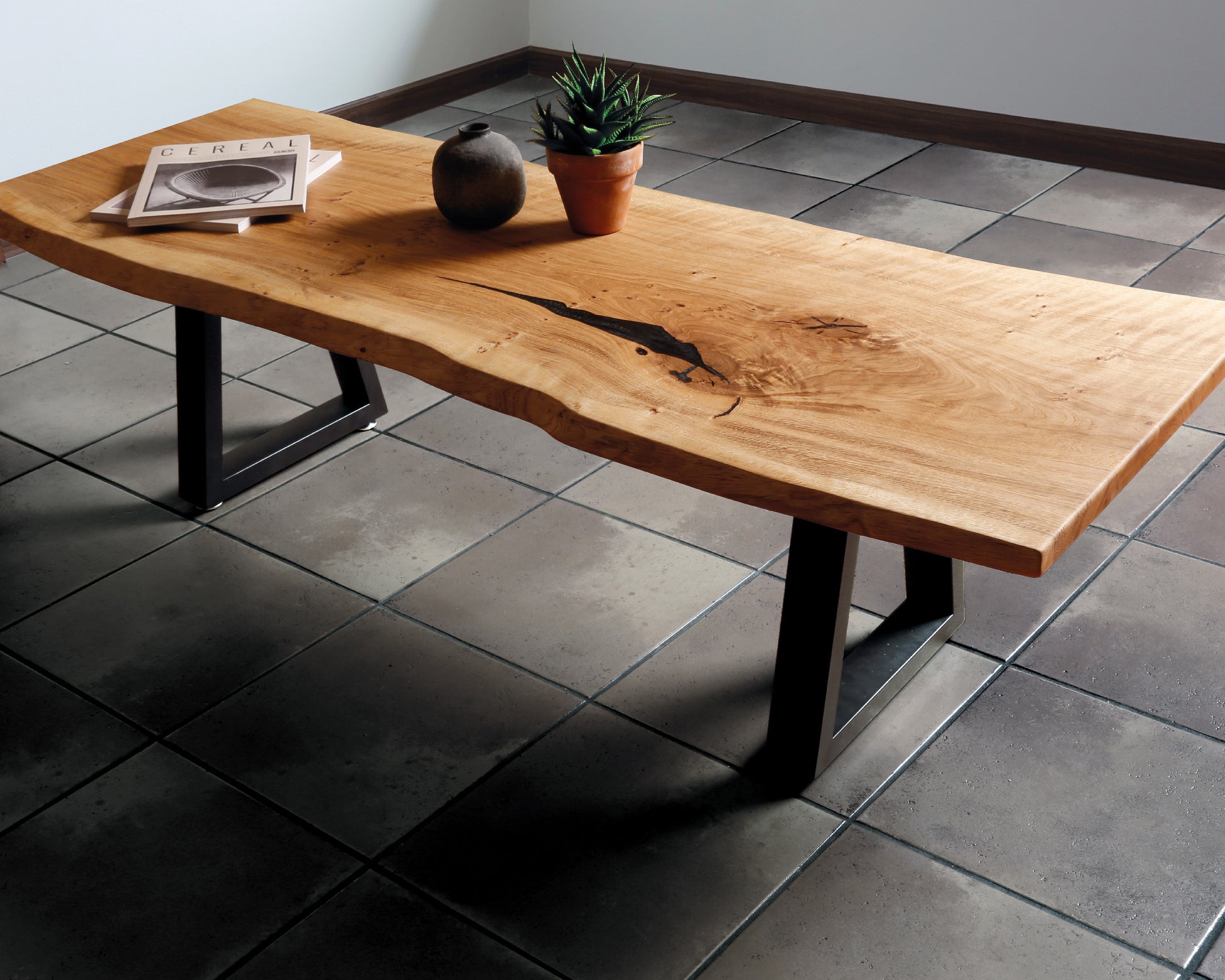 Elegant live edge coffee table with natural waney edges, black resin wood filler, and modern black trapezoid legs. Stylish and unique centerpiece.